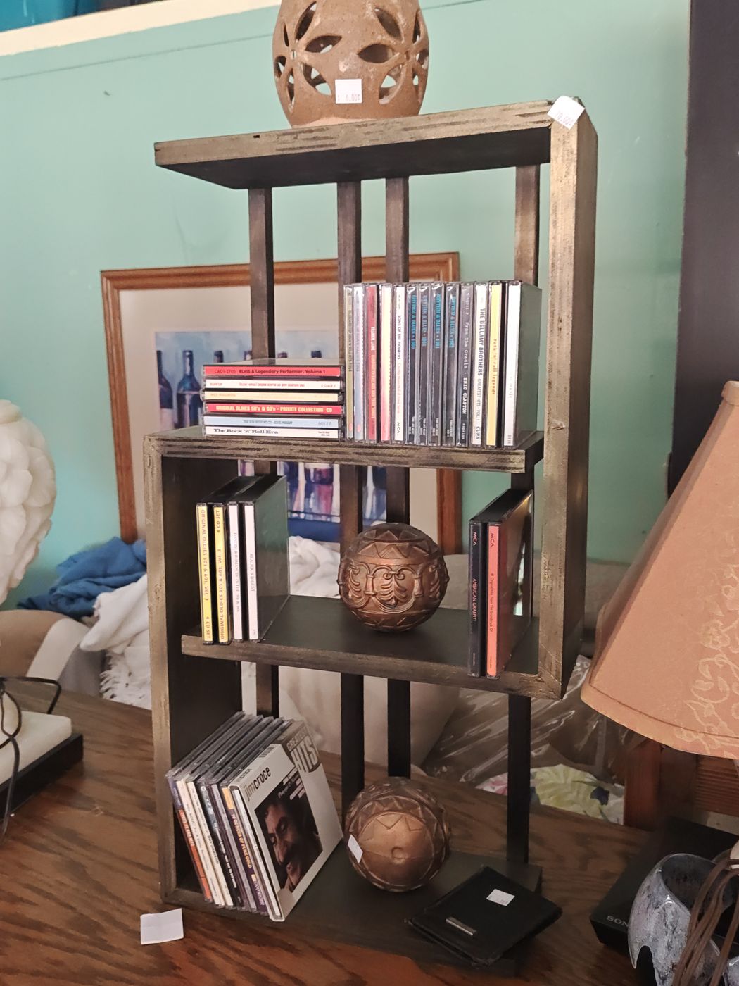 Small shelf of CDs with decorative pieces