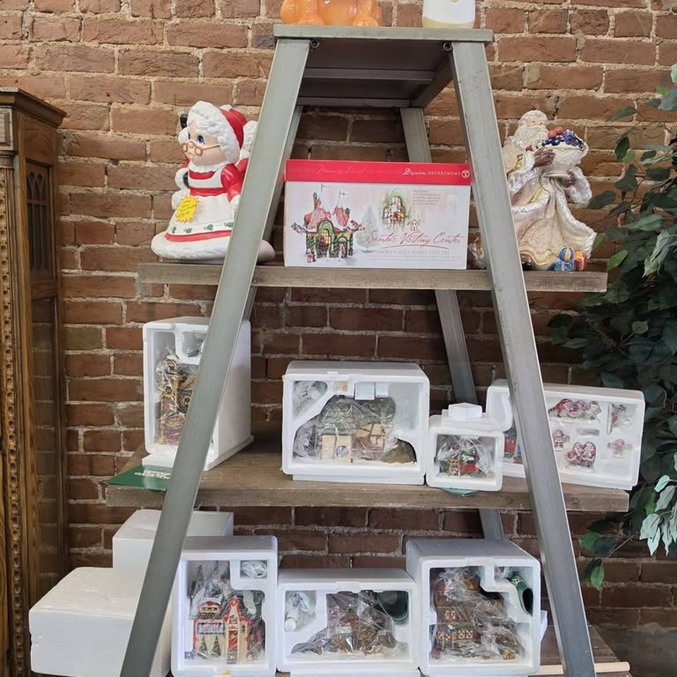 Department 56 Dickens Village pieces displayed on a ladder shelf