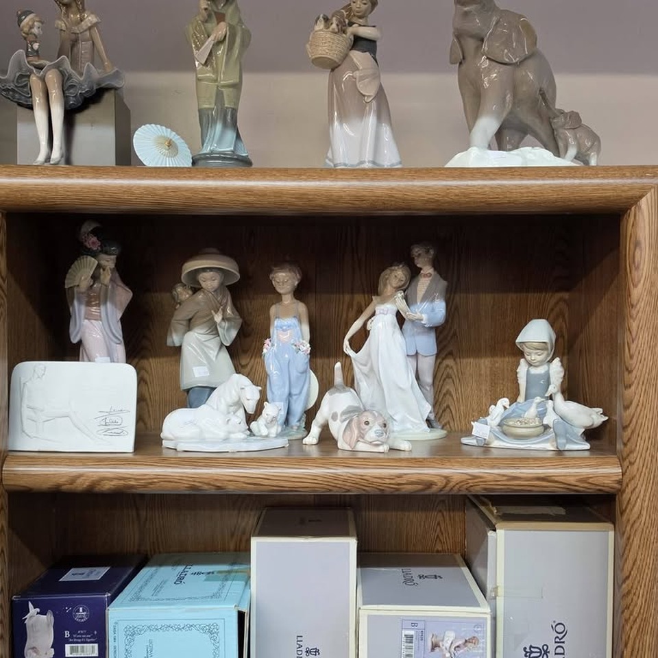 Bookcase of Lladro porcelain figurines with original Lladro boxes below